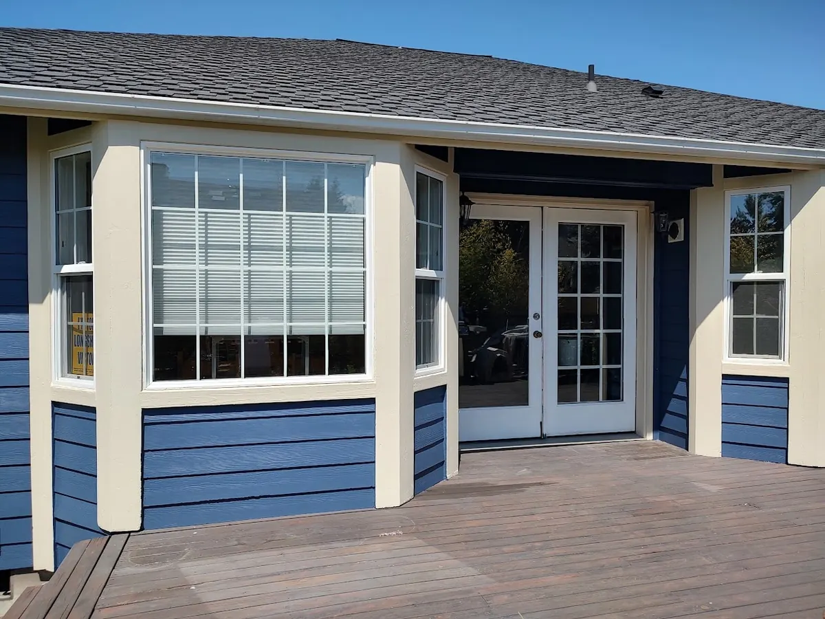 Blue house with cream bay window trim, repainted by our crew