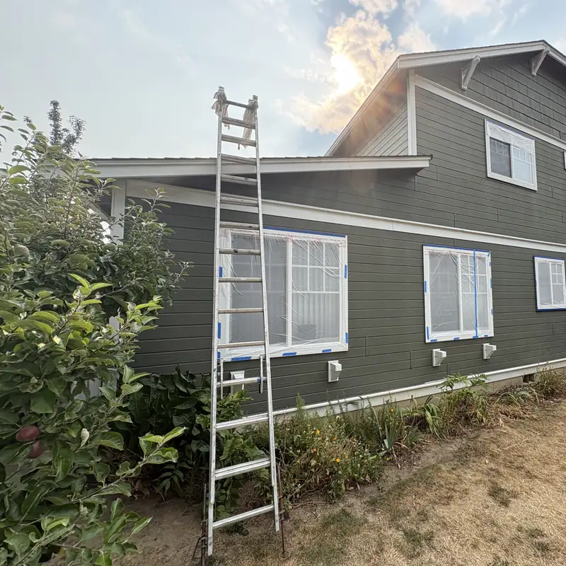 Ladder set up beside windows masked off for spraying