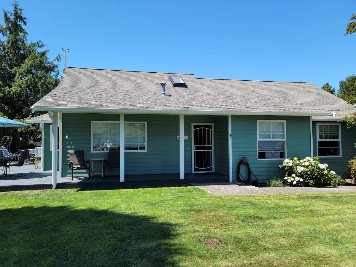 Single-story teal house with white porch posts, repainted by our crew