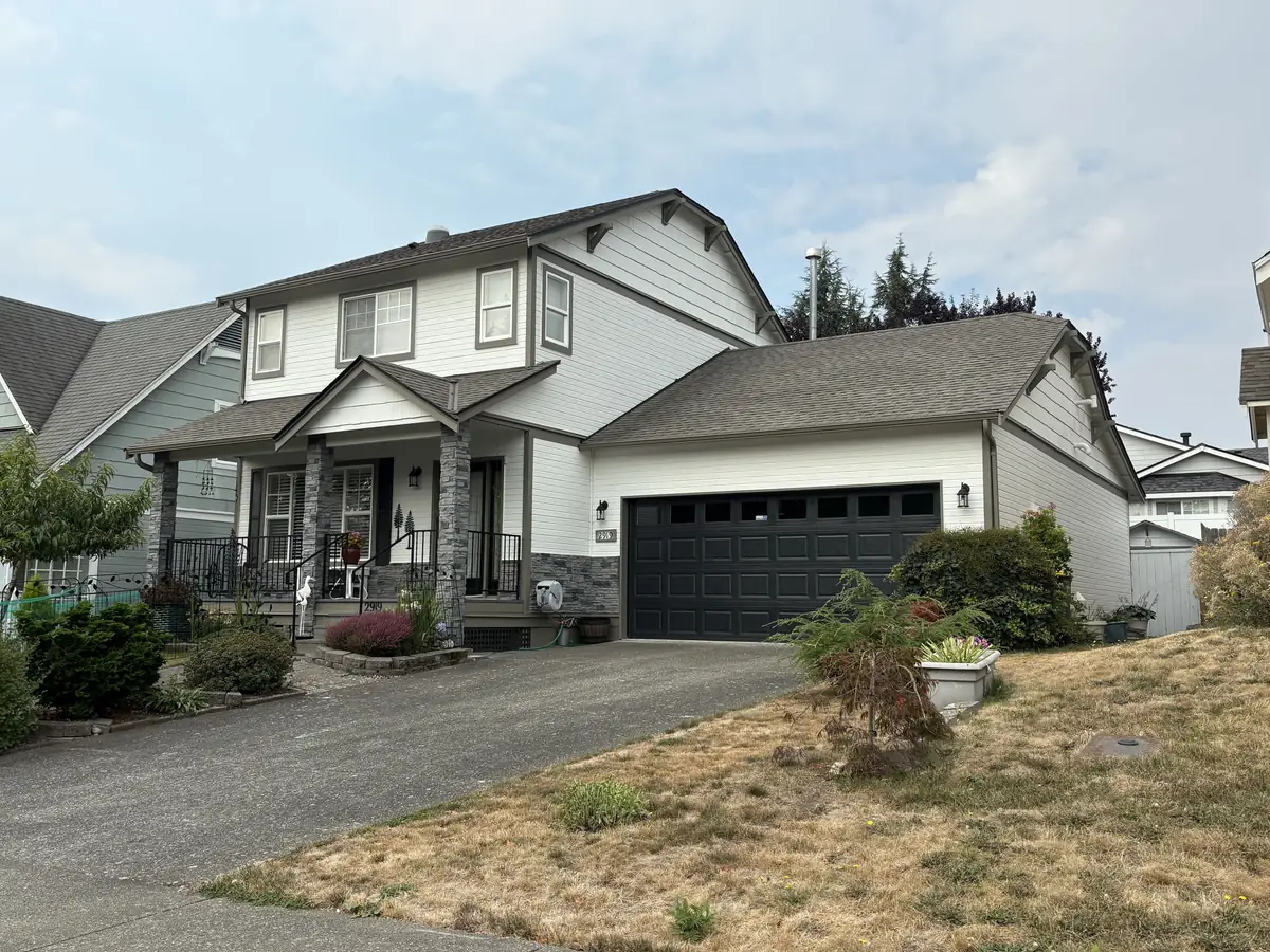 Two-story house with white siding and dark trim, painted by our crew